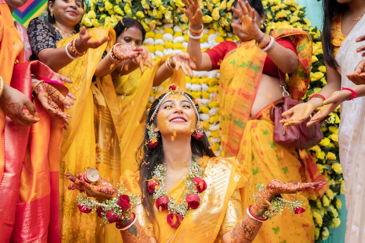 Colorful Indian Haldi ceremony with joyful women applying turmeric paste to the bride-to-be.