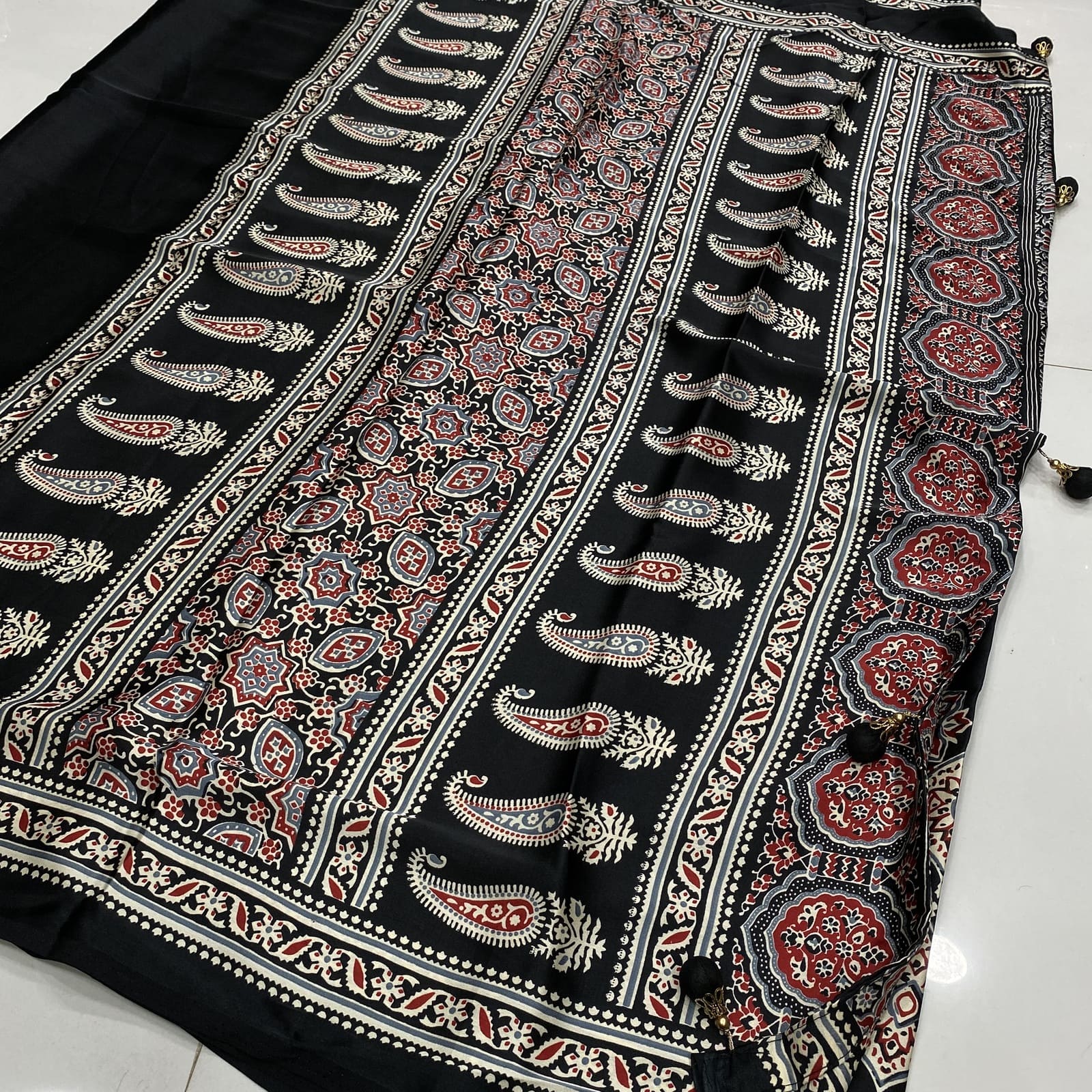 Black satin finish saree with matching ajrak print pallu and designer tassels