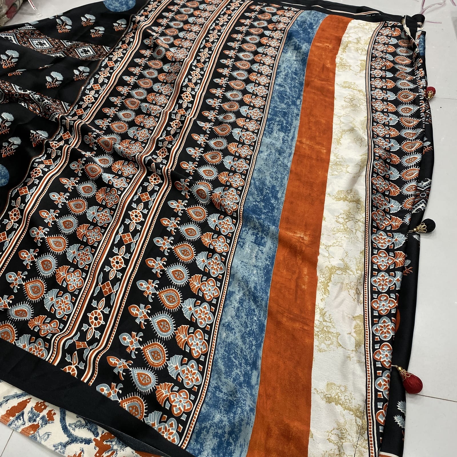 Black satin finish printed saree pallu with rich design and designer tassels
