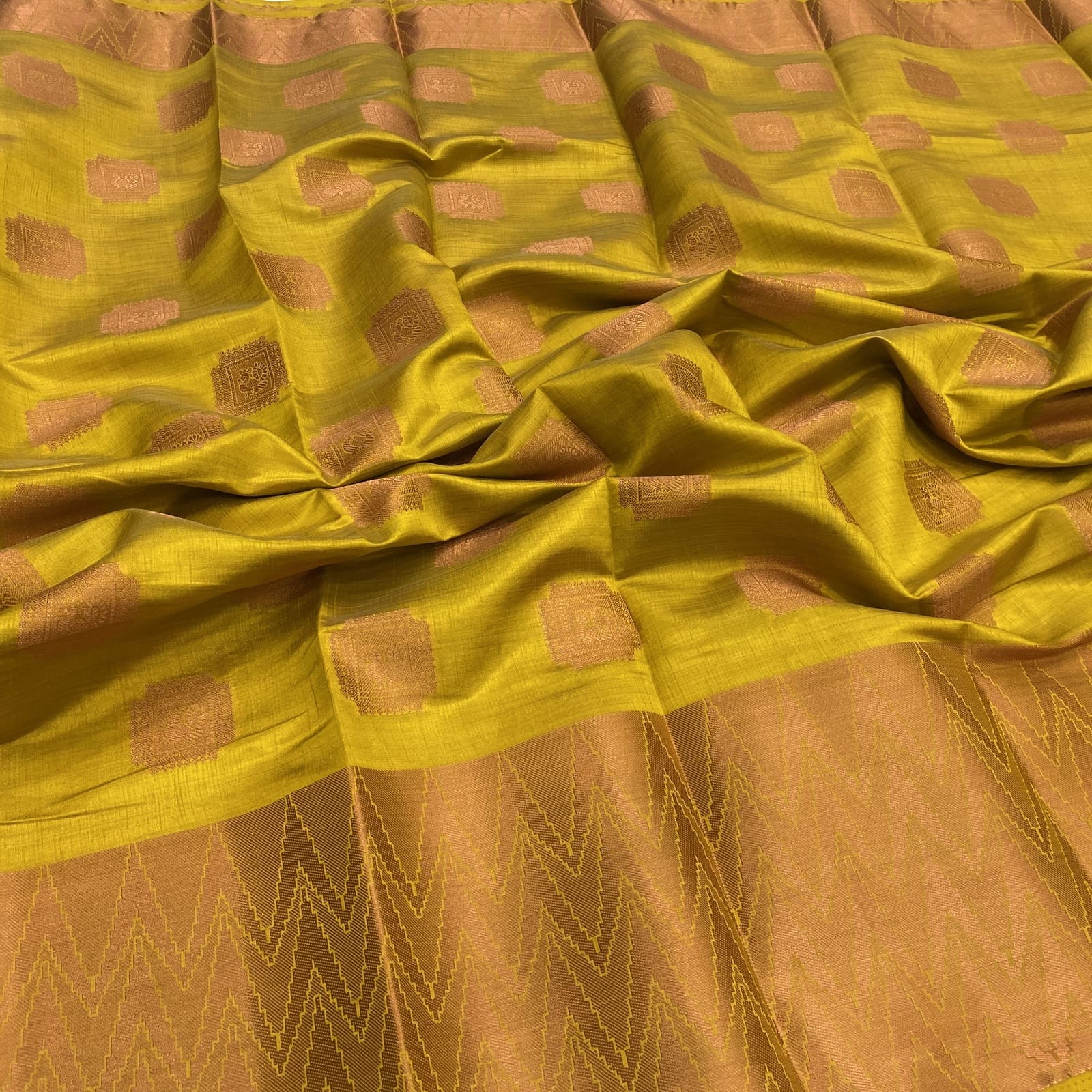 Yellow tussar silk saree with peacock copper butta and waves kanchi border