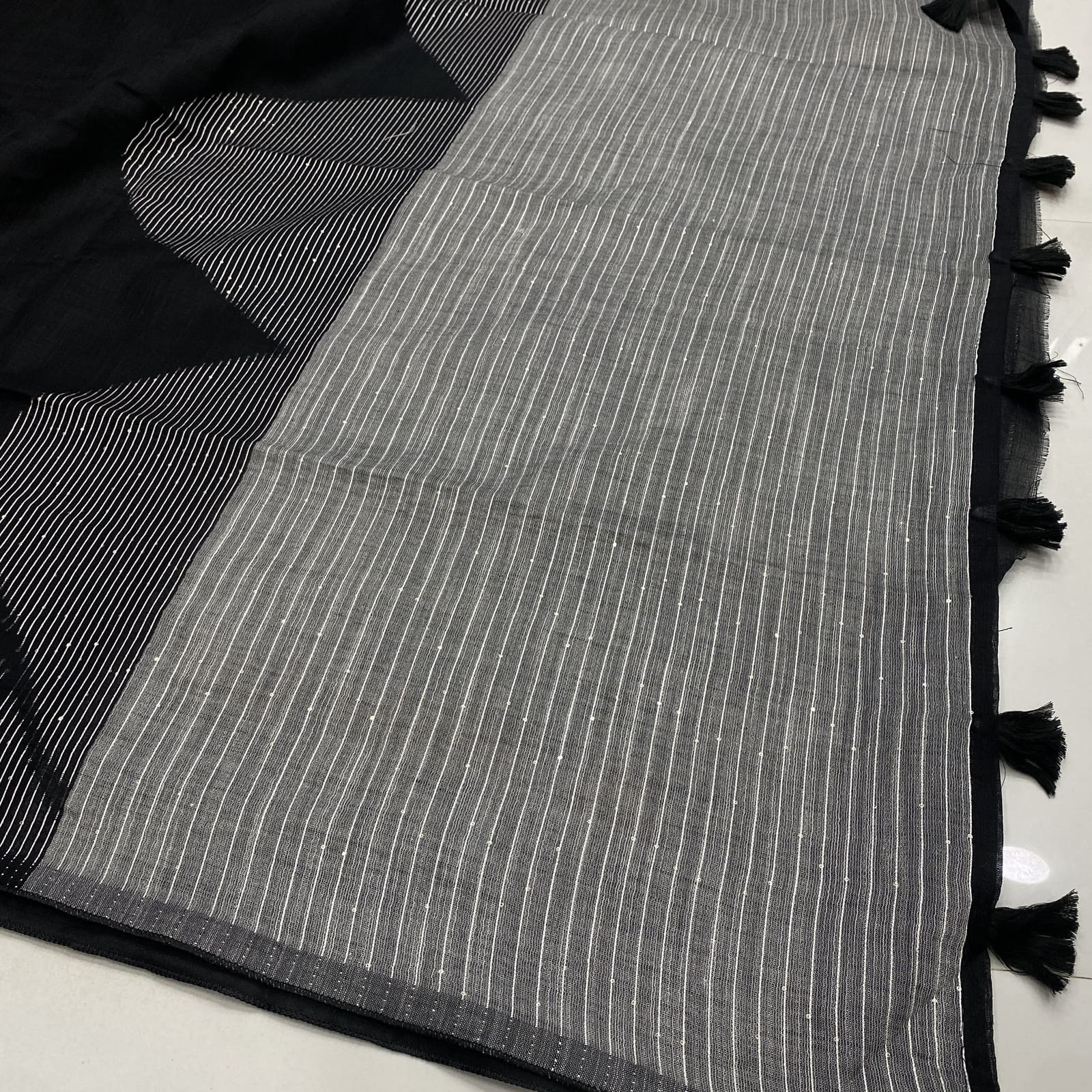 Striped contrast pallu with tassels in black linen saree