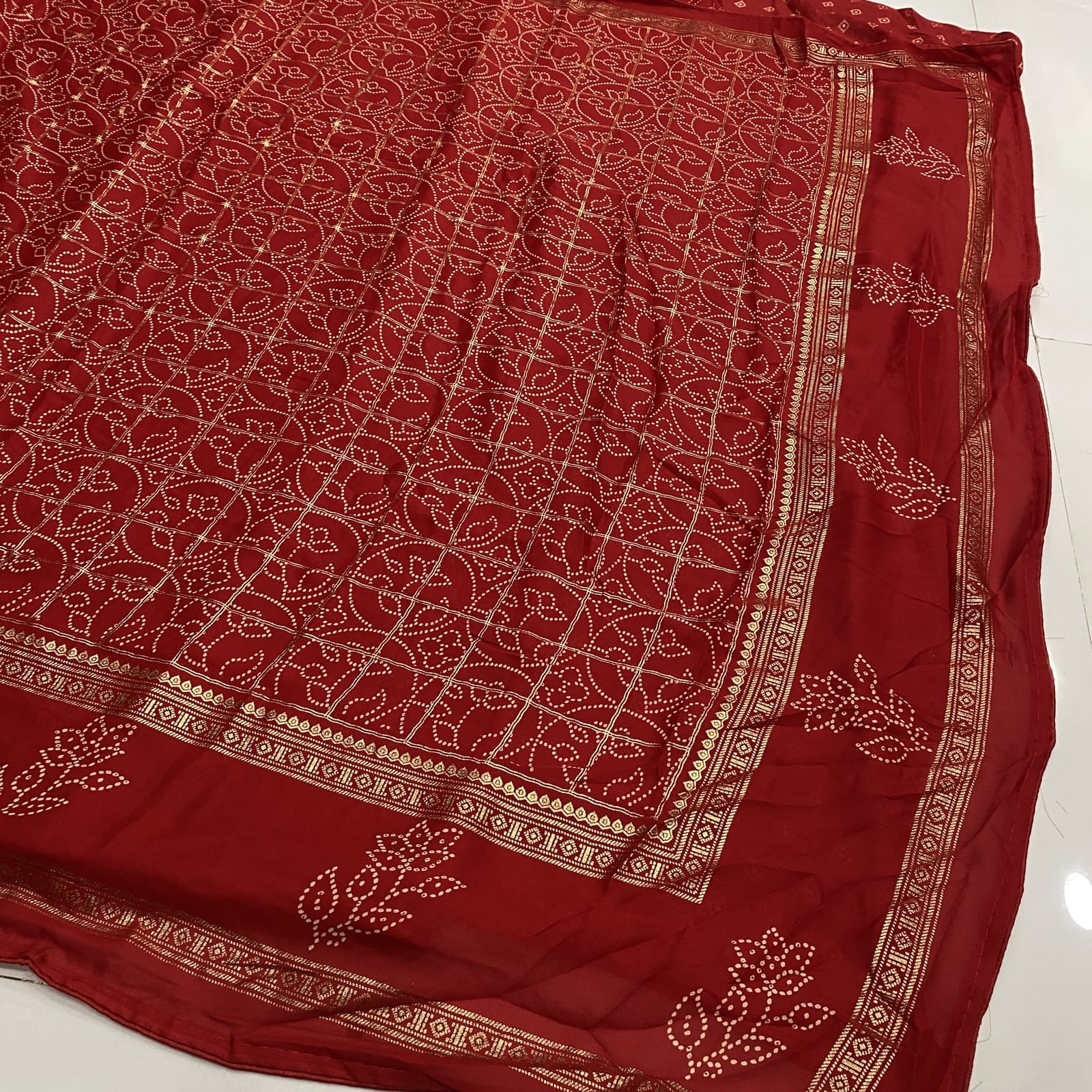 Red saree pallu with gold foil border and floral motifs